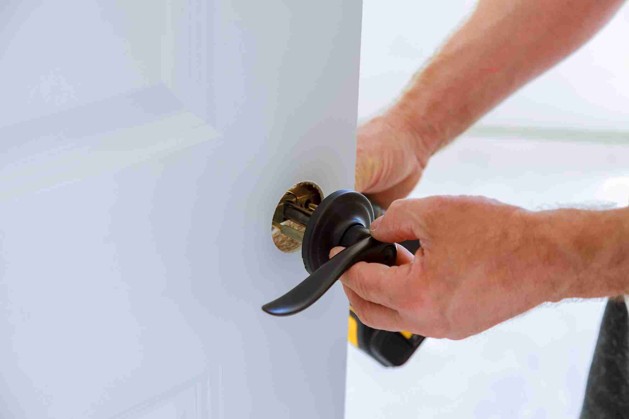 change locks, locksmith installing the lock on the door