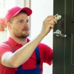 Locksmith technician performing house door lock maintenance