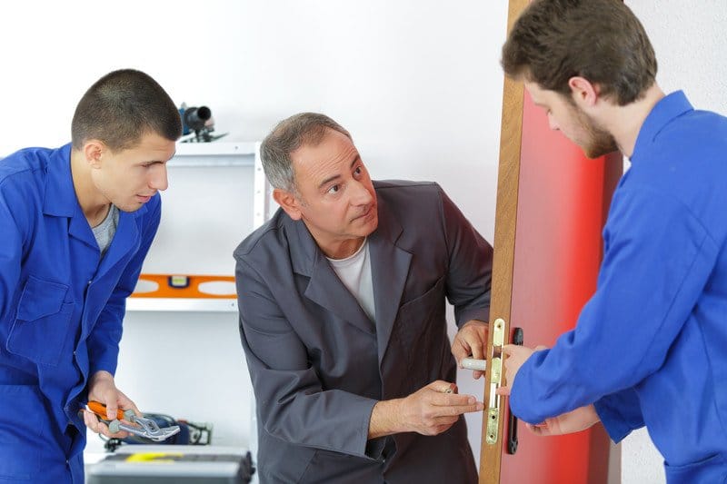 Locksmith students training in workshop with teacher